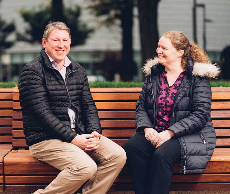 Photo of Dr Philip and Professor Emma Crosbie sat on a bench in Brunswick Park